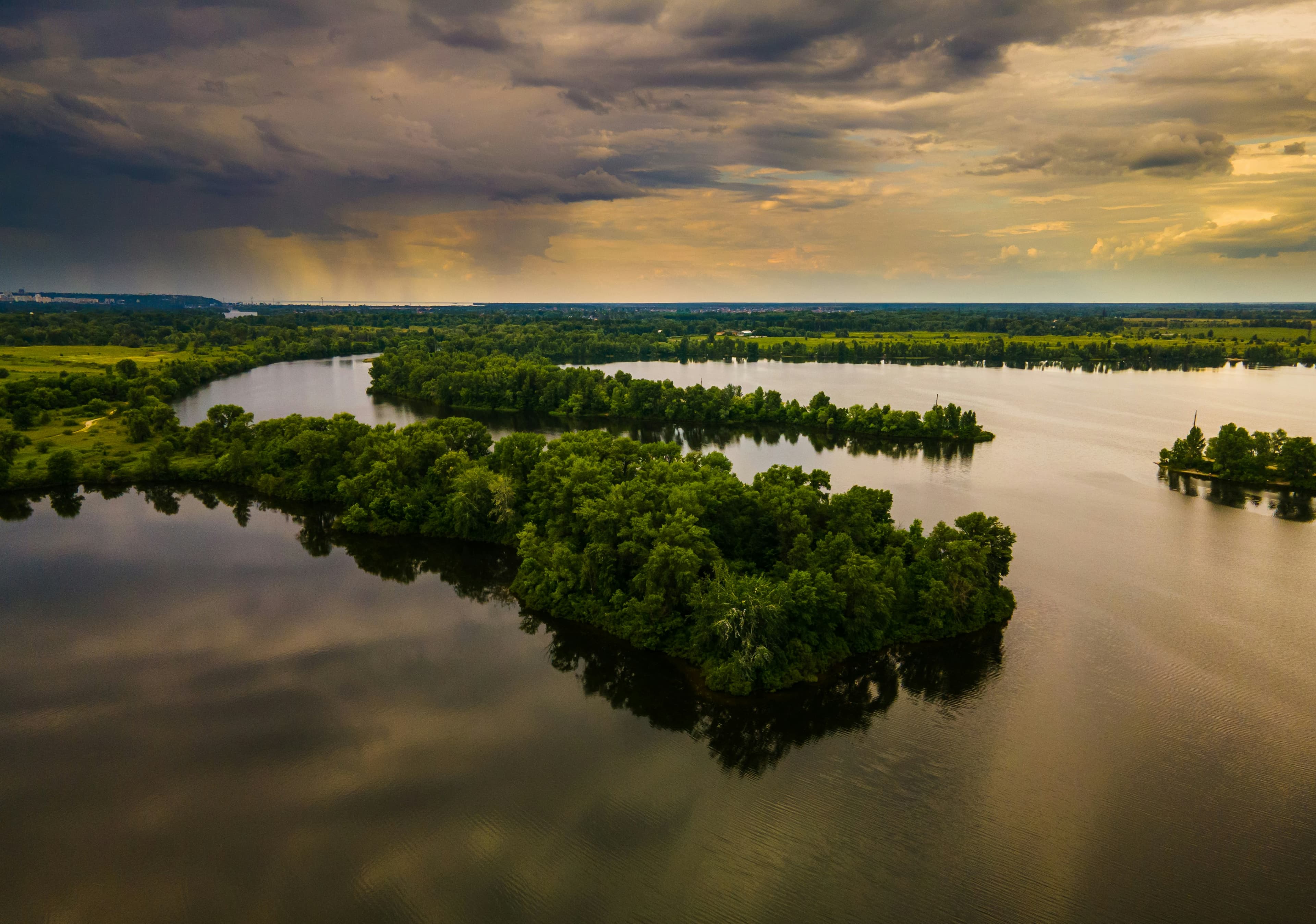 Aerial view of a fishing lake surrounded by forest at dawn